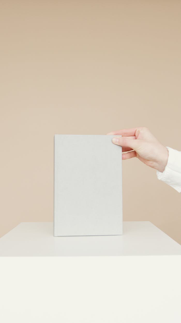 ours-journey Simple minimalist image of a blank book being held by a person's hand, ideal for branding.